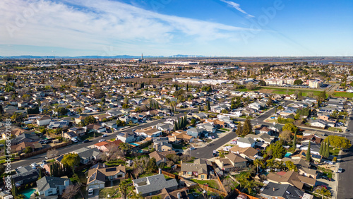 Drone photos over a community in California with houses, streets and cars.
