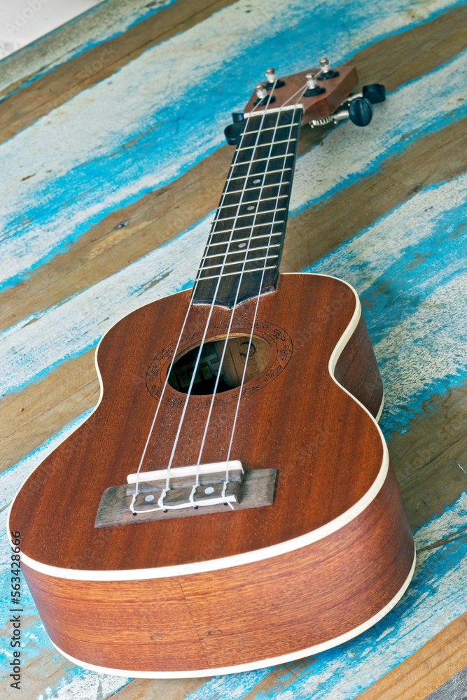 Obraz premium Ukulele, a small Hawaiian guitar, on rustic board