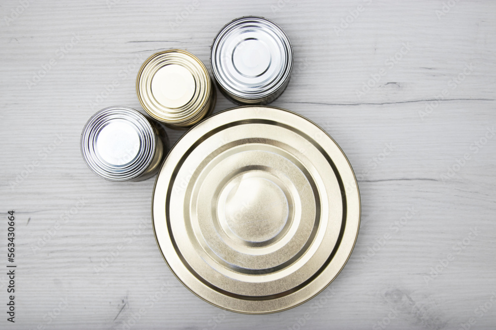 Various closed tin cans with food preserves on a light background. Canned food concept. Food donations. Copy space Various closed tin cans with food preserves on a light background. Canned food concept. Food donations. Copy space
