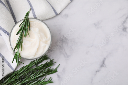 Delicious pork lard with rosemary in glass on white marble table, flat lay. Space for text