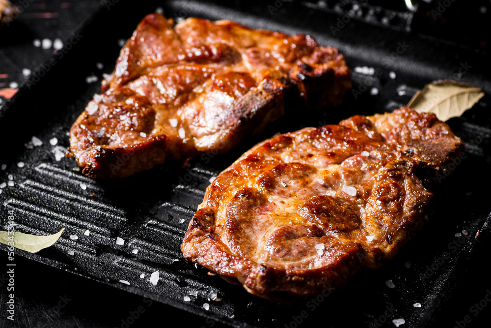 Grilled pork steak in a frying pan. 