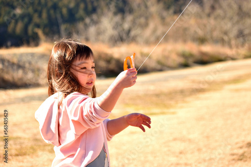 河川敷で凧あげをする女の子