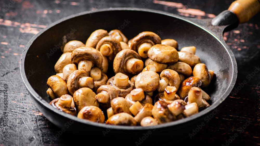 Fried small mushrooms in a frying pan. Fried small mushrooms in a frying pan.