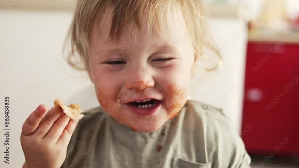 Closeup view of funny dirty small boy after eating pizza. Tomato lips and teeth. Child licking fingers. Closeup view of funny dirty small boy after eating pizza. Tomato lips and teeth. Child licking fingers.