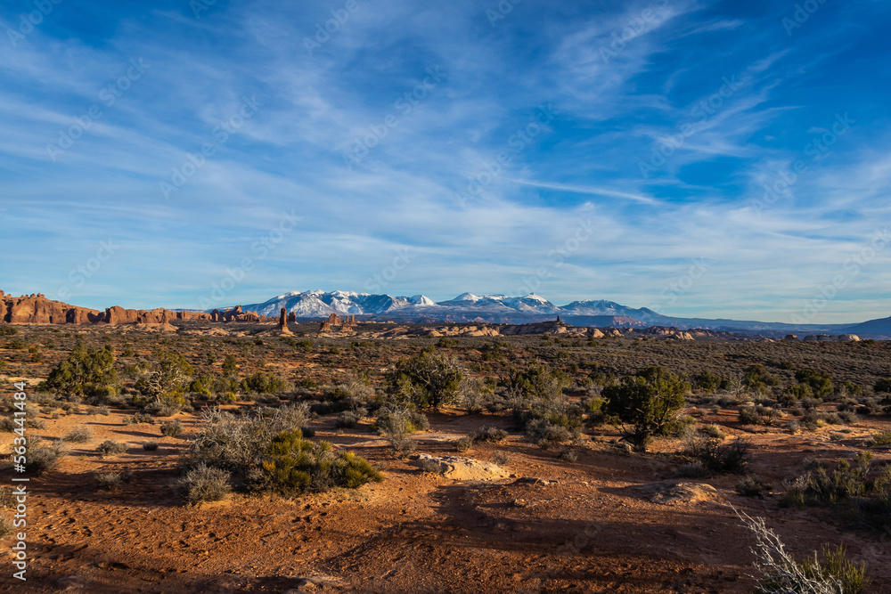 Rock formations with distant snow-covered mountains in the distance in Arches National Park.