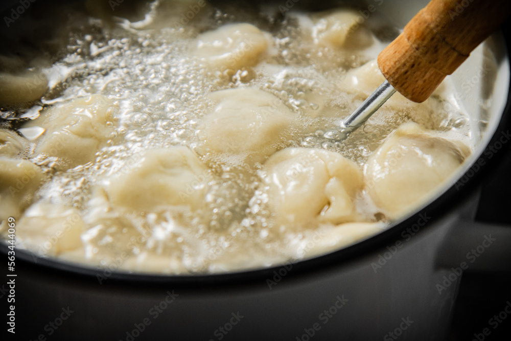 Dumplings are boiled in a saucepan in boiling water. Dumplings are boiled in a saucepan in boiling water.
