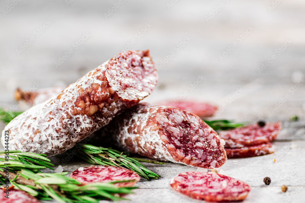 Pieces of salami sausage with sprigs of rosemary. Pieces of salami sausage with sprigs of rosemary.