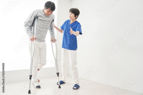 骨折して松葉杖で歩く男性