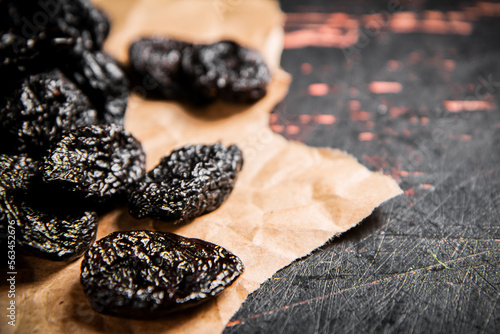 Prunes on paper on the table. 