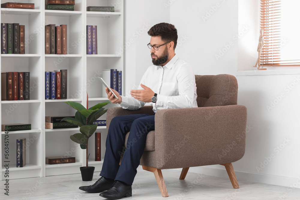 Male psychologist video chatting with patient in office Male psychologist video chatting with patient in office