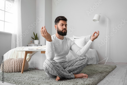 Handsome young man meditati...