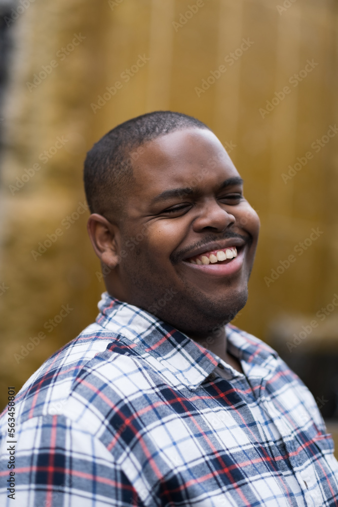 In an outdoor public space, a young African American man expresses confidence In an outdoor public space, a young African American man expresses confidence