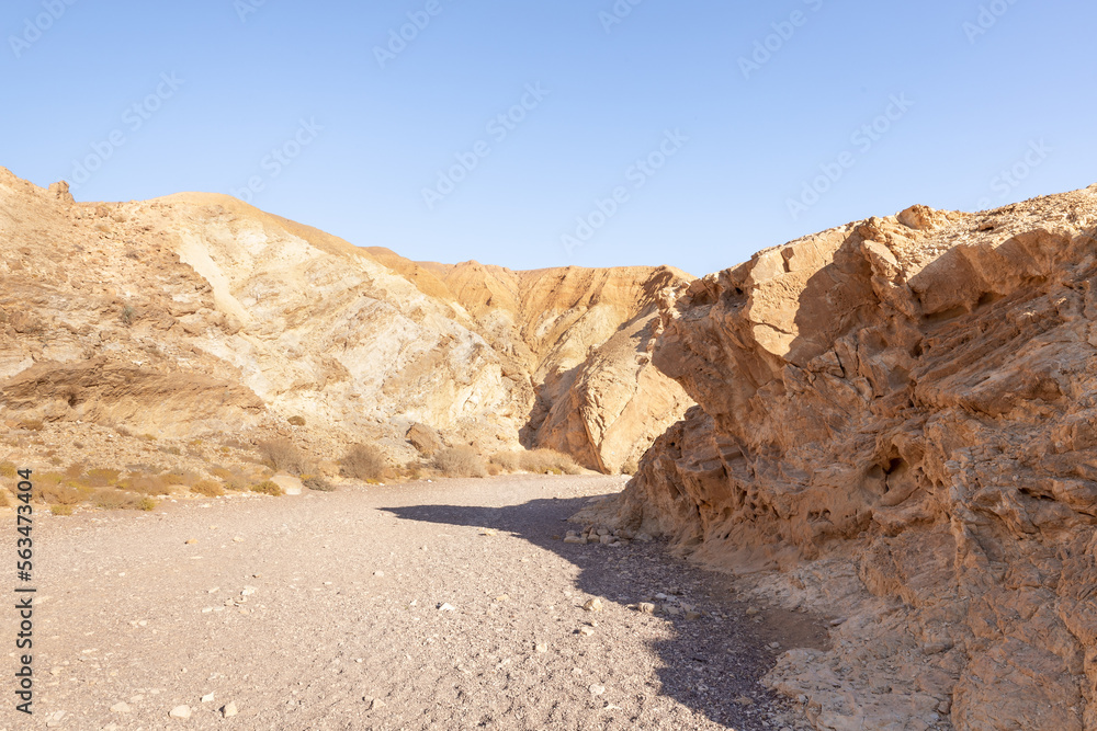 The dried  up river bed - the path to the Red Canyon, in the national reserve - the Red Canyon in the rays of the setting sun, near the city of Eilat, in southern Israel.
