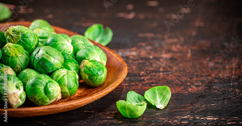 Fresh Brussel cabbage on a wooden plate.  © Artem Shadrin