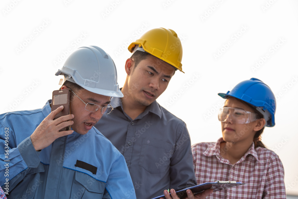 Engineers coworker discuss construction projects in workplace construction site. group of technician architect planning with blueprint and construction tools Engineers coworker discuss construction projects in workplace construction site. group of technician architect planning with blueprint and construction tools