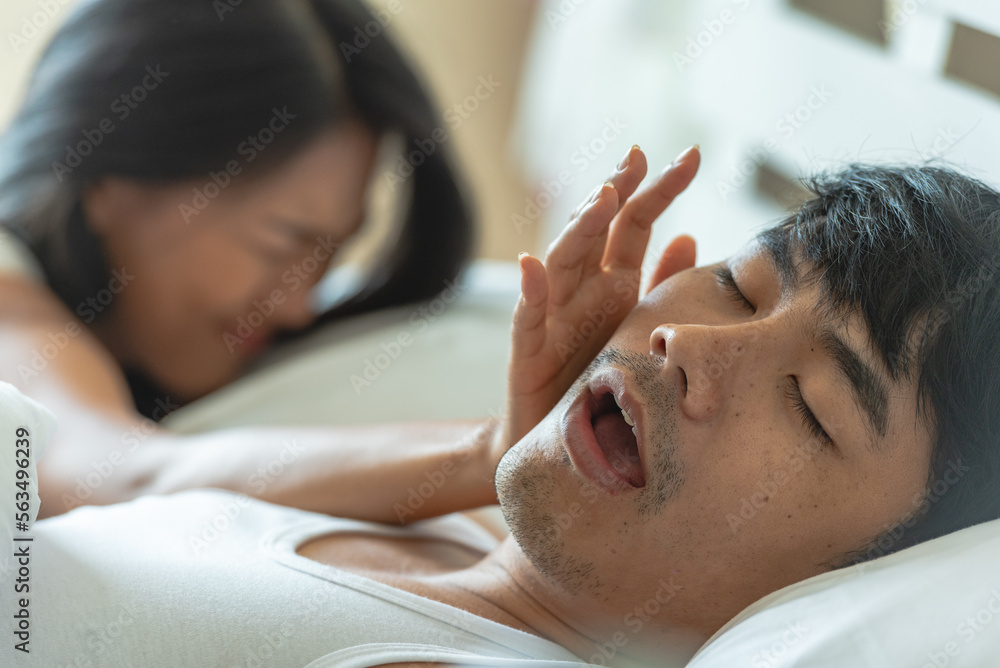 Lover couple happy in love relaxing on bed looking in eye smiling with big red heart shape pillow in valentine day honeymoon Lover couple happy in love relaxing on bed looking in eye smiling with big red heart shape pillow in valentine day honeymoon