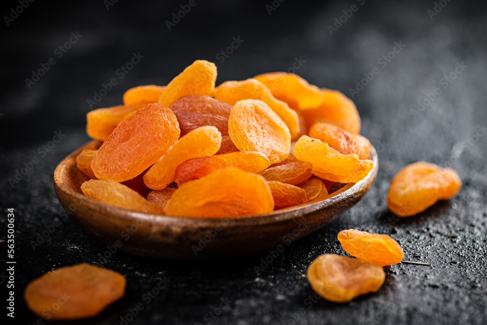 Dried apricots in a wooden plate on the table. Dried apricots in a wooden plate on the table.