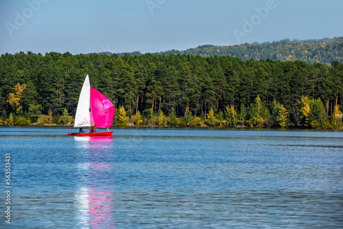 sailboat floats on a blue lake 