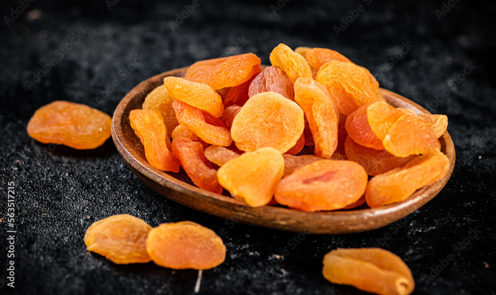 Dried apricots in a wooden plate on the table. Dried apricots in a wooden plate on the table.