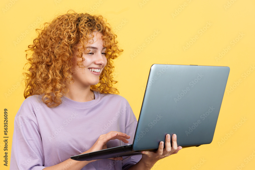 Smiley woman standing and using a laptop Smiley woman standing and using a laptop