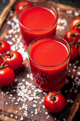Tomato juice in a glass with pieces of salt. 