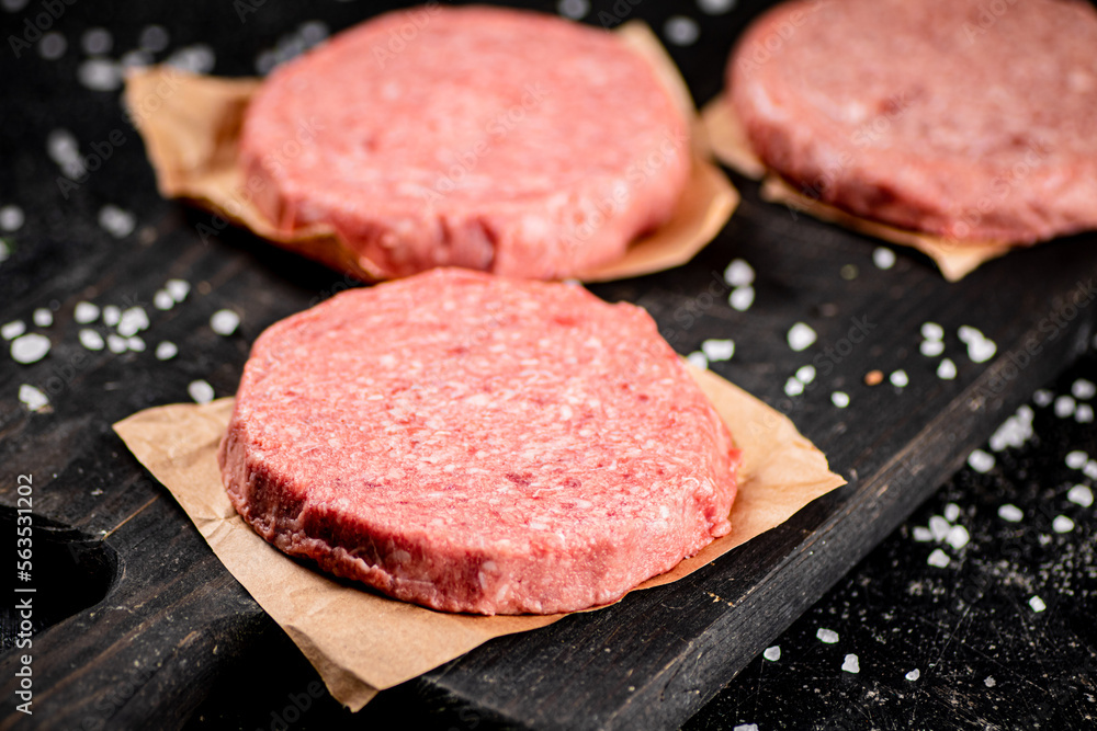 Raw burger on a cutting board. Raw burger on a cutting board.