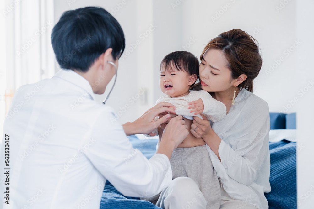 家を訪問したドクターに診てもらう赤ちゃん 家を訪問したドクターに診てもらう赤ちゃん