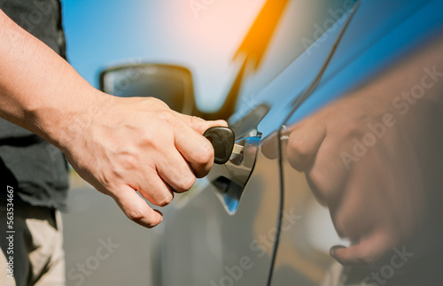 Hands with keys opening the car door. Close-up of hands opening the car door with the key. Vehicle owner opening the door with the keys.