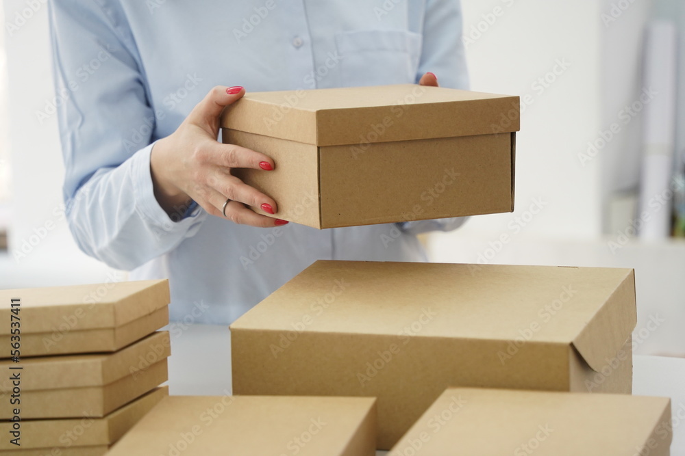 A woman holds cardboard boxes for parcels and delivery A woman holds cardboard boxes for parcels and delivery