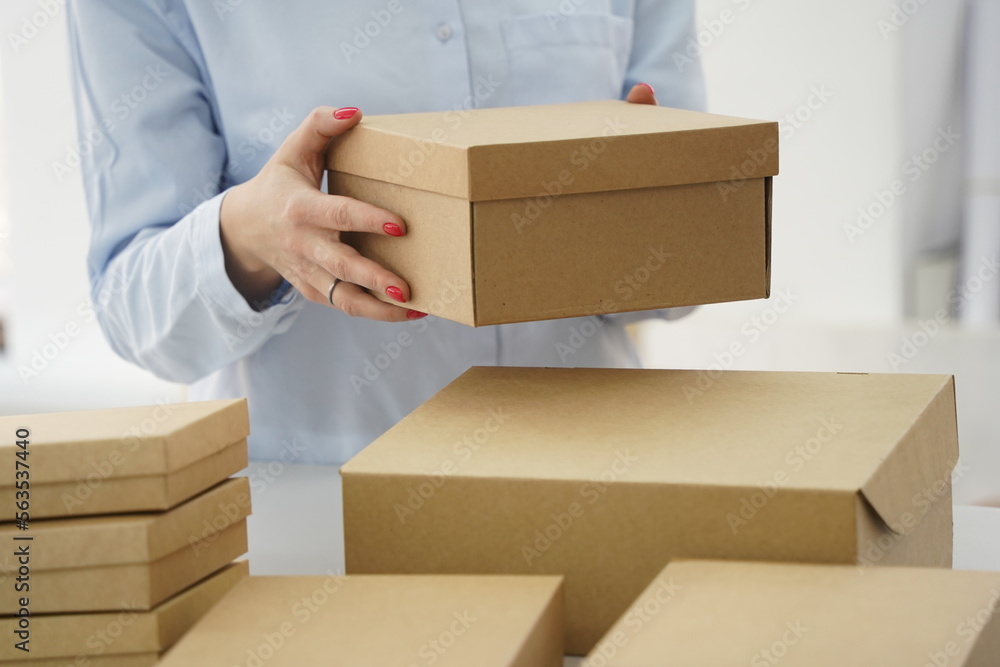 A woman holds cardboard boxes for parcels and delivery A woman holds cardboard boxes for parcels and delivery