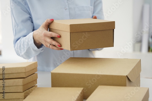 A woman holds cardboard boxes for parcels and delivery © Vladimir