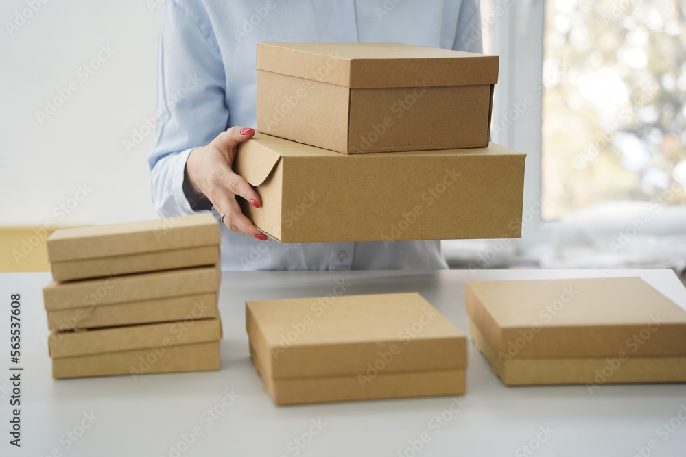 A woman holds cardboard boxes for parcels and delivery A woman holds cardboard boxes for parcels and delivery