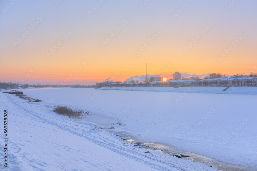 View of the rising sun on a frosty morning in the city. The frozen Volga from the Athanasius Nikitin embankment in the city of Tver. Dawn in winter.