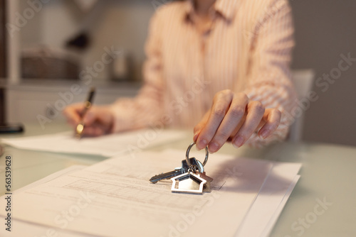 Realtor shows keys and signing documents. Close-up of hands. Concept of leasing and mortgage photo