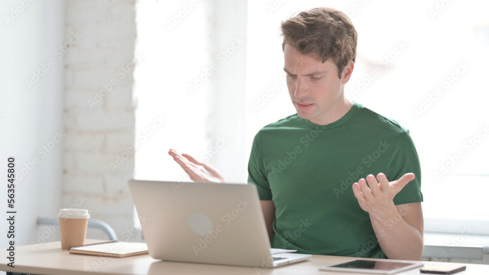 Young Man Upset while Reading Business Report at Work Young Man Upset while Reading Business Report at Work