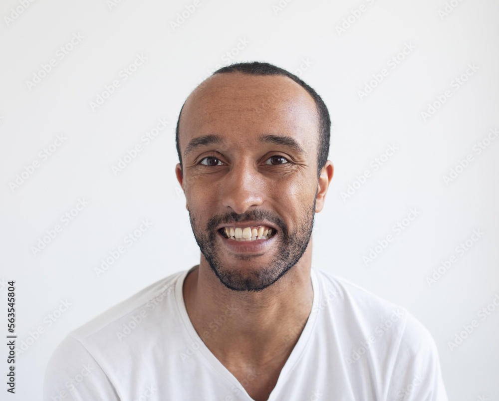 A young unshaven man on a light gray background. African American. A young unshaven man on a light gray background. African American.