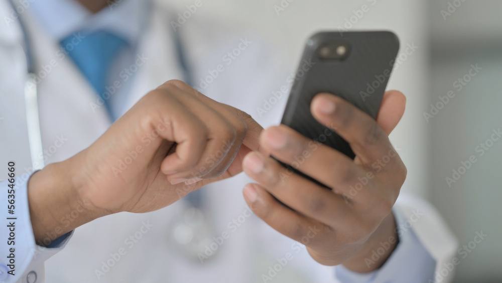 African Doctor Text Messaging on Smartphone, Close Up