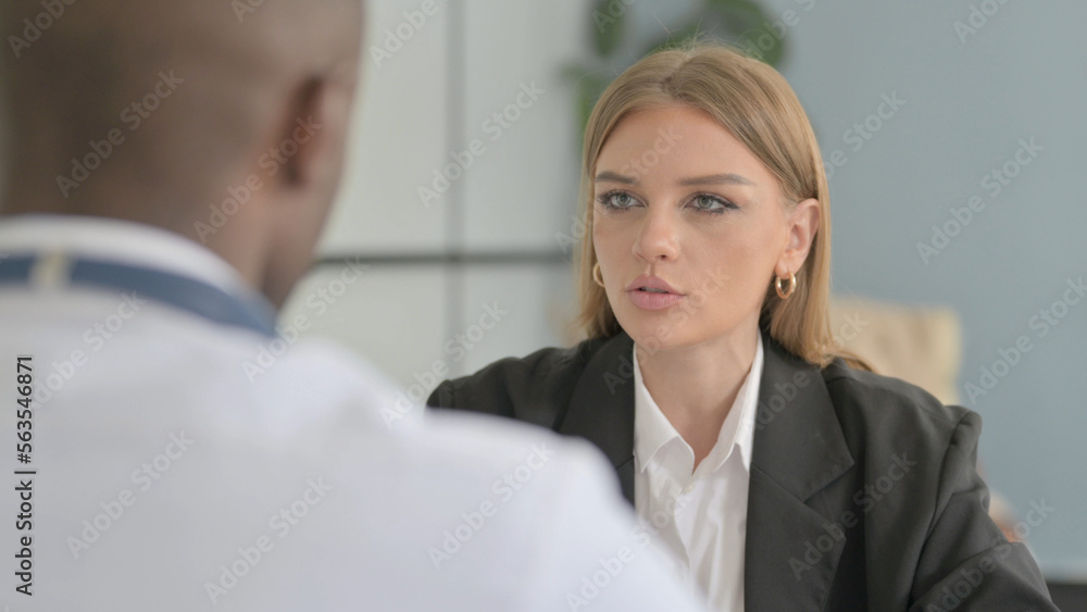 Female Patient Talking with African Doctor in Clinic Female Patient Talking with African Doctor in Clinic