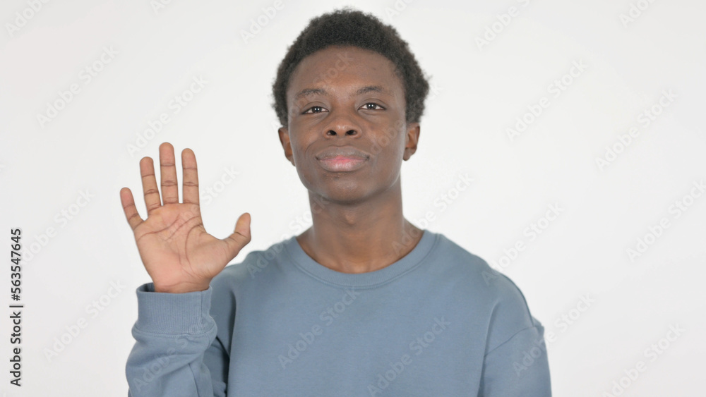 Fototapeta premium Young African Man Waving Hand to Say Hello on White Background