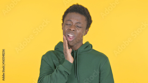 Young African Man having Toothache on Yellow Background © stockbakers