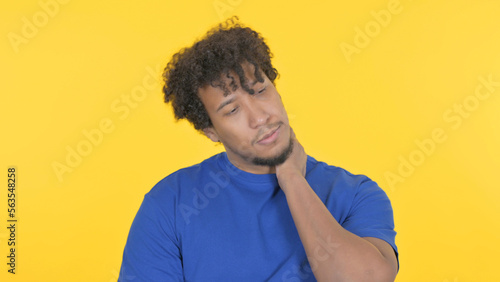 African Man with Neck Pain on Yellow Background