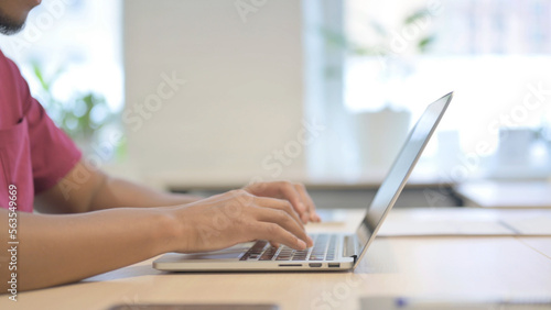 Side View of African Man Typing on Laptop