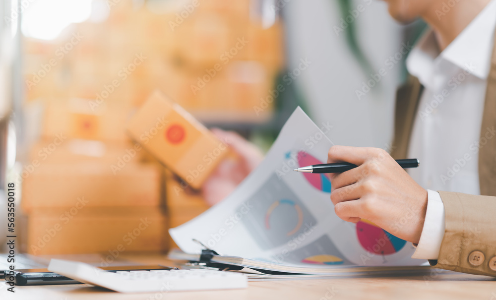 Fototapeta premium Startup or small business entrepreneur,check business growth report,order management in online stores, shopping on the internet,Selling online on the Internet,SME,shipping boxes,e-commerce