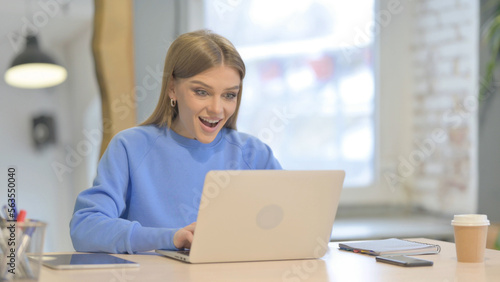 Woman Celebrating Online Success on Laptop in Office