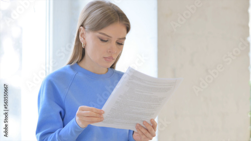 Close Up of Woman Reading Documents while Sitting in Window