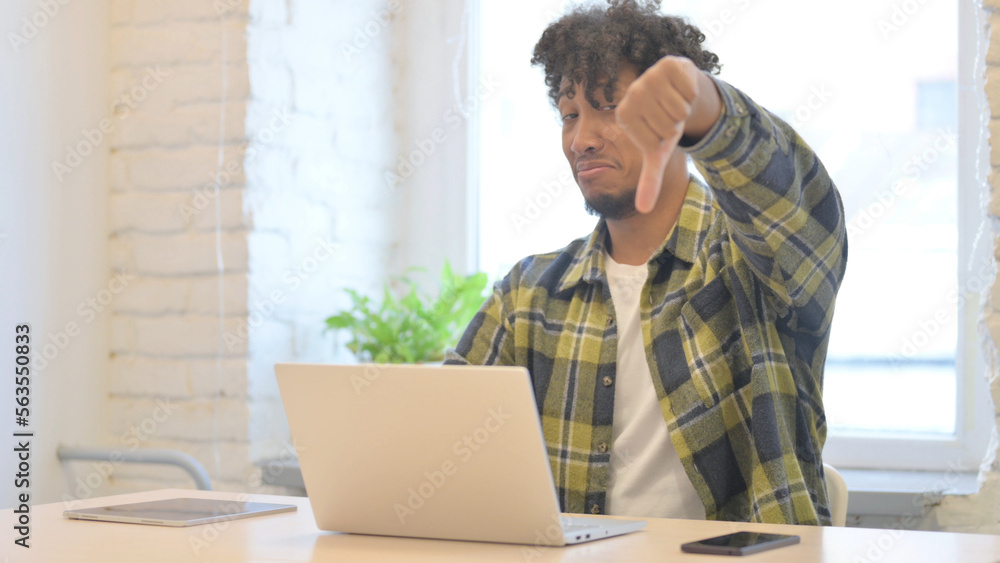 Thumbs Down by African Man Working on Laptop