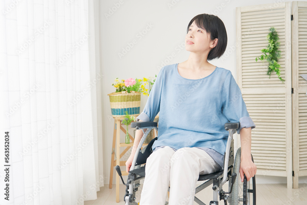 家で車椅子に乗る障がい者女性　全身