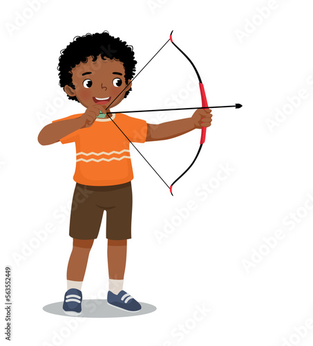 Cute little African boy with bow and arrow doing archery sport aiming ready to shoot