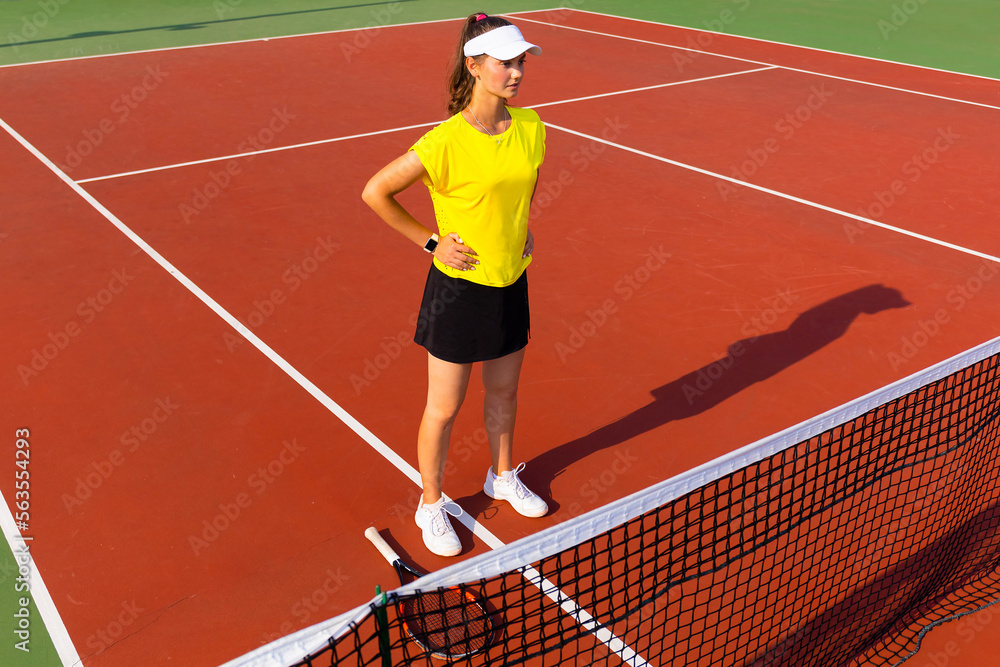 Fototapeta premium Pretty sportswoman with racquet at the tennis court. Healthy lifestyle.