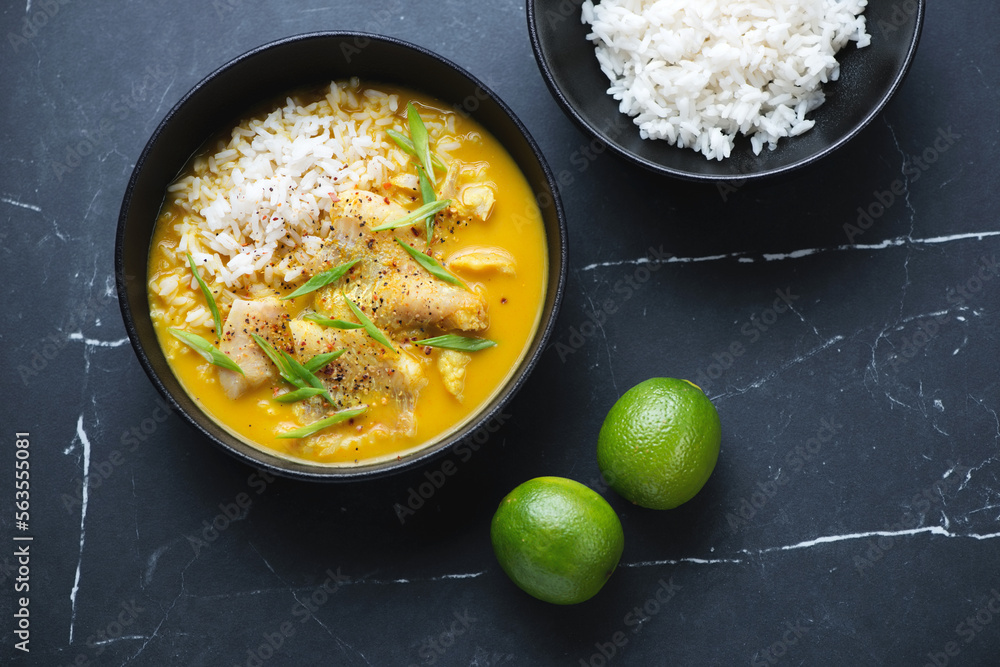 Yellow curry with fish and white rice on a black marble background, horizontal shot, above view Yellow curry with fish and white rice on a black marble background, horizontal shot, above view
